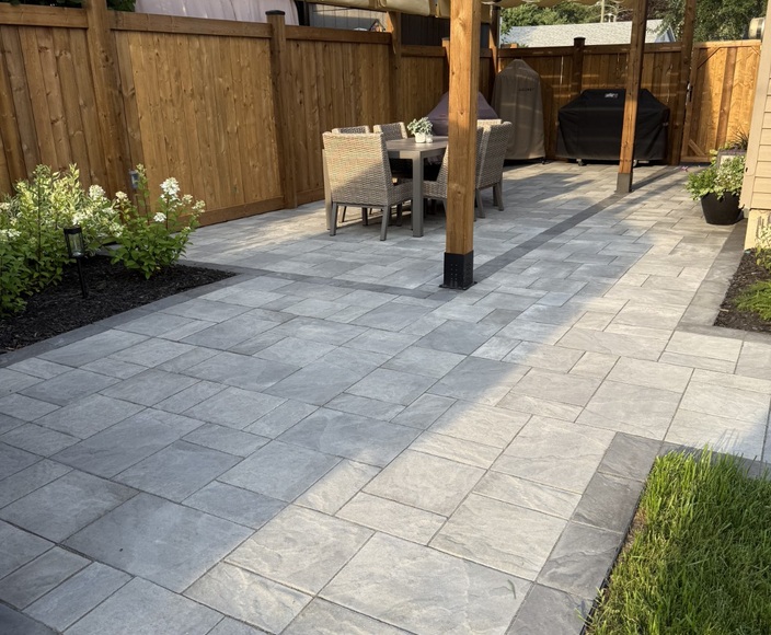 Stone patio with timber pergola, outdoor seating and raised planters